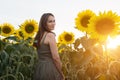 Woman In Green Dress Walks Across Sunflowers On Field