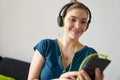 Woman With Green Earphones Listens Podcast Music On Telephone Royalty Free Stock Photo