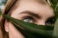 Woman with green eyes close up covered with leaf Royalty Free Stock Photo