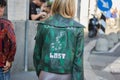 Woman with green jacket with Paradise Lost writing before Salvatore Ferragamo fashion show, Milan Fashion