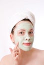 Woman with green mask on her face, cream