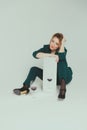 A woman in a green pantsuit is holding a mirror and a glass of red wine is standing in front of her Royalty Free Stock Photo