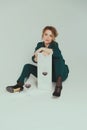 A woman in a green pantsuit is holding a mirror and a glass of red wine is standing in front of her Royalty Free Stock Photo