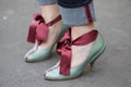 Woman with green shoes with dark red satin ribbon before Salvatore Ferragamo fashion show, Milan Fashion Week