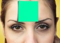 Woman with green sticky note on her forehead Royalty Free Stock Photo