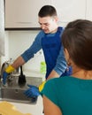 Woman in green watching plumber's work Royalty Free Stock Photo