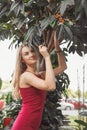 Woman in greenhouse posing at tropical tree