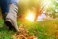 Woman in grey shoes and jeans walking on the autumn forest path Royalty Free Stock Photo