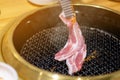 Woman grilling pork in a Korean restaurant