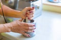 A woman grinds nuts in a mortar. Seasoning making