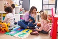 Woman and group of kids having lesson using touchpad at kindergarten Royalty Free Stock Photo