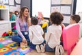 Woman and group of kids having vocabulary lesson with word cards at kindergarten Royalty Free Stock Photo