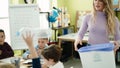 Woman and group of kids throwing plastic bottle on paper bin recycling at classroom Royalty Free Stock Photo