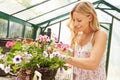 Woman Growing Plants In Greenhouse