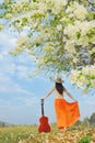 Woman and guitar standing and flower Cloud sky