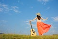 Woman and guitar standing on guitar with Cloud sky