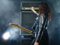 Woman guitarist turning knobs on amplifier Royalty Free Stock Photo