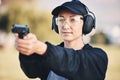 Woman, gun and learning to shoot weapon at shooting range outdoor for security, training and target. Person with safety