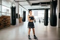 Woman in gym shorts and shirt using boxing bandage at gym. wrap injured hand.