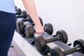 Woman in the gym takes a dumbbell from the rack Royalty Free Stock Photo