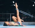 Woman, gymnastics and spinning hoop on leg for competition, sports training and action in arena. Female dancer, rhythmic