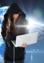 Woman hacker using a laptop in front of blue digital background