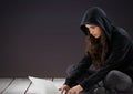 Woman hacker using a laptop in front of purple background Royalty Free Stock Photo