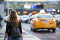 woman hailing taxi outside busy airport terminal