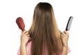 A woman with the hair over her face holding comb and hair brush