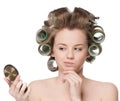 Woman in hair roller looking in mirror Royalty Free Stock Photo