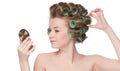 Woman in hair roller looking in mirror Royalty Free Stock Photo