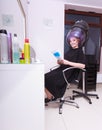 Woman hair rollers curlers reading magazine hairdryer beauty salon Royalty Free Stock Photo