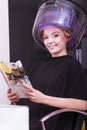 Woman hair rollers curlers reading magazine hairdryer beauty salon Royalty Free Stock Photo