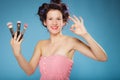 Woman in hair rollers holds makeup brushes Royalty Free Stock Photo