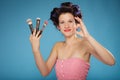 Woman in hair rollers holds makeup brushes Royalty Free Stock Photo