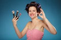 Woman in hair rollers holds makeup brushes Royalty Free Stock Photo