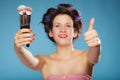 Woman in hair rollers holds makeup brushes Royalty Free Stock Photo