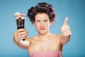 Woman in hair rollers holds makeup brushes Royalty Free Stock Photo