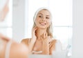 Woman in hairband touching her face at bathroom