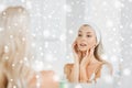 Woman in hairband touching her face at bathroom