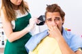 The woman hairdresser applying dye to man hair