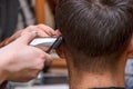 Woman Hairdresser cuts man's hair with electric clipper trimmer