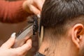Woman Hairdresser cuts man's hair with electric clipper trimmer