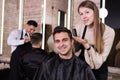 Woman hairdresser discussing hairstyling with male client