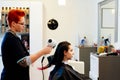 Woman hairdresser drying young woman customer hair in salon Royalty Free Stock Photo