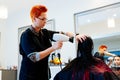 Woman hairdresser drying young woman customer hair in salon Royalty Free Stock Photo