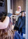 Woman with hairdresser looking hair dye sample in Royalty Free Stock Photo