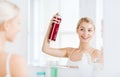 Woman with hairspray styling her hair at bathroom Royalty Free Stock Photo