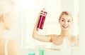 Woman with hairspray styling her hair at bathroom Royalty Free Stock Photo