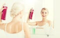 Woman with hairspray styling her hair at bathroom Royalty Free Stock Photo